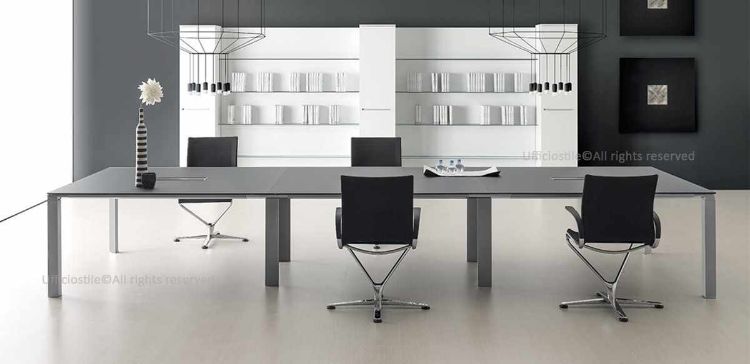Tavolo riunioni modulare da 420 x 140 cm composto da 3 moduli da 140 cm ciascuno, con piano in MDF spessore 18 mm rivestito in melaminico nero opaco e piani terminali dotati di top access con spazzoline e sportello apribile per la gestione ordinata dei cavi.