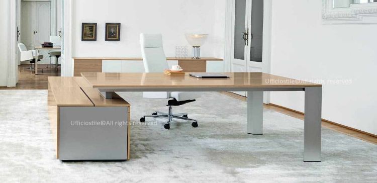 Scrivania direzionale Ono da 200 x 100 cm con piano in MDF e struttura a ponte in metallo a forma trapezoidale, mobile di servizio portante da 200 x 70 cm composto da due ante e tre cassetti, vano con serratura, cassettiera con chiusura simultanea e cassetti in PVC colore alluminio su guide a rullo ad estrazione parziale.