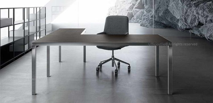 Scrivania angolare Linea 403 con piano da 180 x 90 cm in melaminico, allungo laterale da 120 x 60 cm, struttura a ponte in alluminio lucido e piani realizzati in pannello ligneo spessore 50 mm con rivestimento in laminatino, disponibili nelle finiture bianco, rovere tabacco o rovere chiaro.