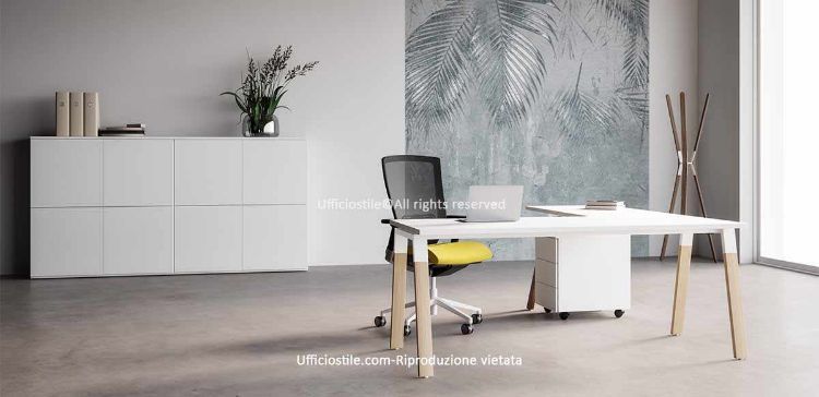Postazione manageriale Ufficiostile® composta da scrivania da 180 x 80 x 73 cm con allungo integrato da 80 cm, piano bianco in melaminico Classe E1 spessore 25 mm, struttura metallo-legno con cavalletto in acciaio e gambe in legno massello, cassettiera metallica su ruote da 42 x 53 x 55 cm con tre cassetti e serratura centralizzata, e madia modulare da 240 x 44 x 123 cm con ante in melaminico a chiusura push-pull, top di finitura coordinato e pannelli bordati in ABS.