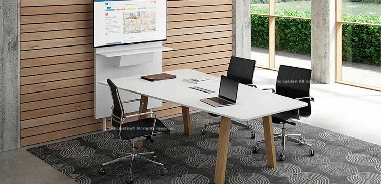 Composizione meeting con tavolo riunioni asimmetrico da 220 x 124 cm, piano in melaminico disponibile in diverse finiture, top access centrale per passaggio cavi da entrambi i lati, gambe a cavalletto in tubo di acciaio trafilato verniciato a polveri epossidiche con rivestimento verticale in melaminico, e Flipper a muro porta video TV con top access, vasca portacavi e telaio metallico con piedini livellatori.