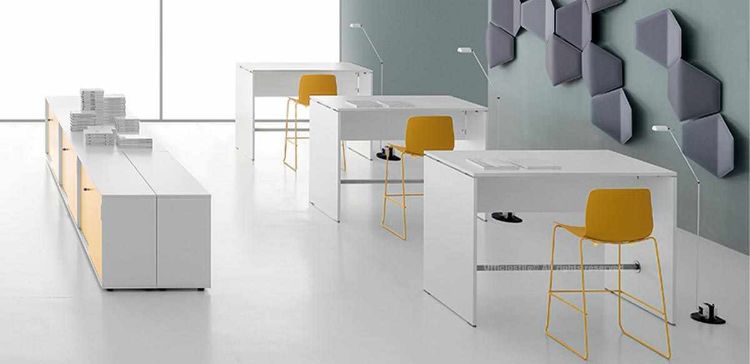 Esempio di arredo operativo composto da tre tavoli alti h.107 da 140 x 80 cm, con tubo in acciaio satinato nella parte inferiore delle gambe, abbinati a un mobile di servizio a sei moduli con ante scorrevoli monofacciali, serratura a pulsante, doppia chiave pieghevole, impugnatura in ABS grigio e piedini livellatori in ABS nero.