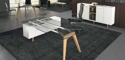 Scrivania a ponte di design con piano in vetro temperato trasparente spessore 12 mm, struttura con due gambe in legno massello, mobile di servizio portante con cassetti con serratura, modulo tecnico e cestello portacavi, completata da credenza contenitore con ante e vani a giorno.