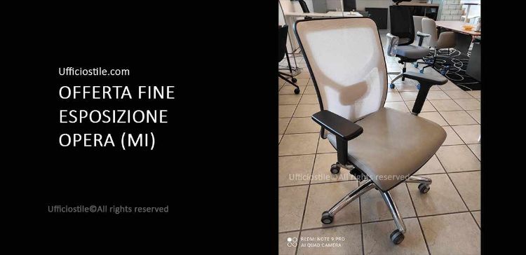Poltrona operativa fine esposizione con schienale in rete bianca, seduta imbottita CAT. A colore 156, basamento a 5 razze in alluminio cromato e braccioli in nylon nero, ideale per postazioni ufficio professionali.