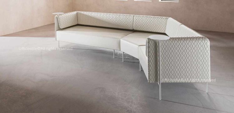 Divano attesa ufficio modulare da 308 cm con schienale trapuntato, composto da moduli configurabili in soluzioni lineari o angolari, completo di due tavolini rotanti integrati e rivestimento tecnico in P.V.C. plastificato e cotone con certificazione di reazione al fuoco del rivestimento.