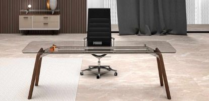 Scrivania direzionale di design con piano in vetro temperato trasparente spessore 12 mm, struttura in legno finitura rovere tabacco, gambe in massello stondate e verniciate a poro aperto, abbinata a mobile contenitore con anta, due cassetti e top in vetro coordinato.