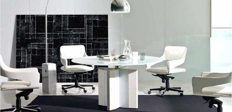 Tavolo riunioni rotondo diametro 140 cm con piano in cristallo extrachiaro spessore 15 mm, struttura con gamba dotata di fianco impiallacciato e bordi rivestiti in cuoio pieno fiore, ideale per sale riunioni direzionali e ambienti ufficio di rappresentanza.
